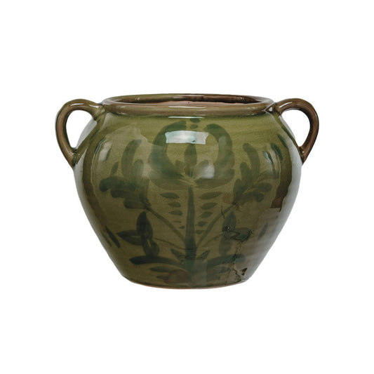 The GREEN HAND-PAINTED TERRACOTTA URN WITH HANDLES by CREATIVE COOP is a round, green ceramic vase with two handles and a glossy finish, featuring hand-painted leaf and floral designs for artisan charm.