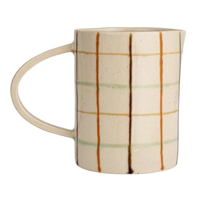 Close-up of the HAND-PAINTED STONEWARE PITCHER by CREATIVE COOP, showcasing an artisanal beige surface with a grid of brown, orange, and light green, plus small dark speckles for added charm.