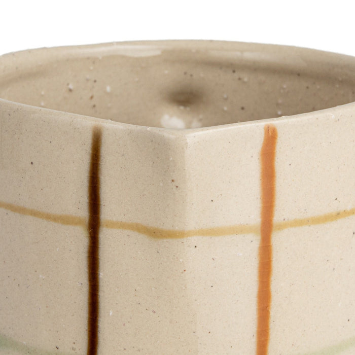 Close-up of the HAND-PAINTED STONEWARE PITCHER by CREATIVE COOP, showcasing an artisanal beige surface with a grid of brown, orange, and light green, plus small dark speckles for added charm.