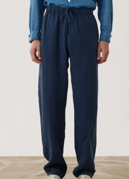 HARTFORD Linen Joggy Pants in Navy feature an elastic waistband, drawstring, side pockets, and a relaxed fit. Crafted from breathable linen by HARTFORD, these joggers are showcased on a plain background.