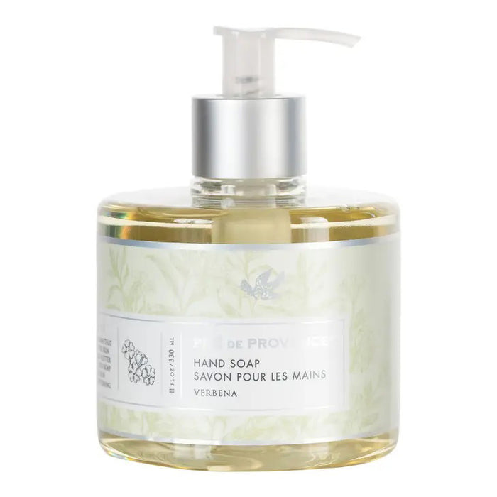 A clear pump bottle holds HERITAGE LIQUID SOAP - VERBENA by EUROPEAN SOAPS, LLC, featuring light yellow soap. The label, in English and French, has a subtle floral design and notes soothing glycerin for gentle cleansing.