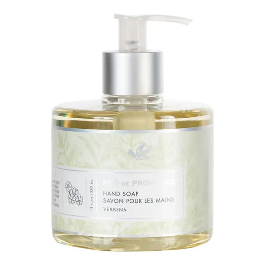 A clear pump bottle holds HERITAGE LIQUID SOAP - VERBENA by EUROPEAN SOAPS, LLC, featuring light yellow soap. The label, in English and French, has a subtle floral design and notes soothing glycerin for gentle cleansing.