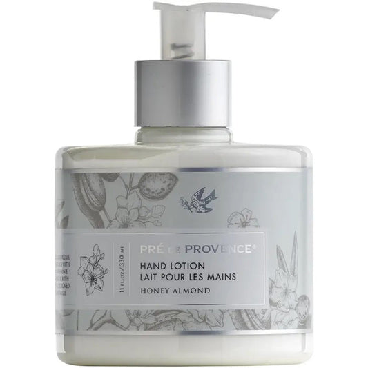A clear pump bottle of EUROPEAN SOAPS, LLC HERITAGE LOTION - HONEY ALMOND with moisturizing shea butter and vitamin E. The white and silver label has floral designs and bilingual English/French text.