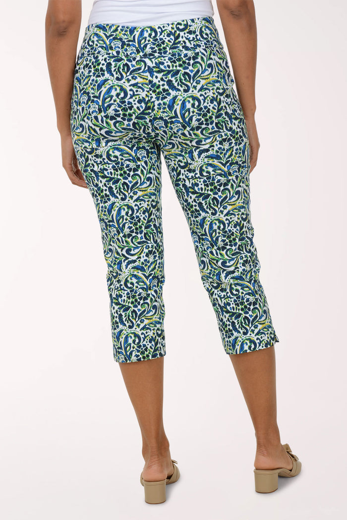 Person wearing a patterned green and blue capri pants on a white background