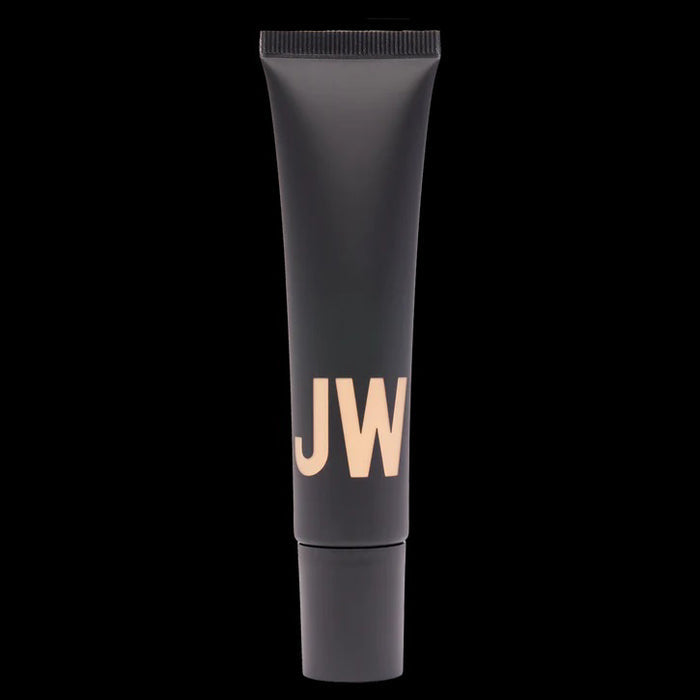 A black tube labeled "JW" stands before a beige swatch, highlighting JASON WU BEAUTY's TINTED MOISTURIZER MEETS CC CREAM for a natural glow on a white background.