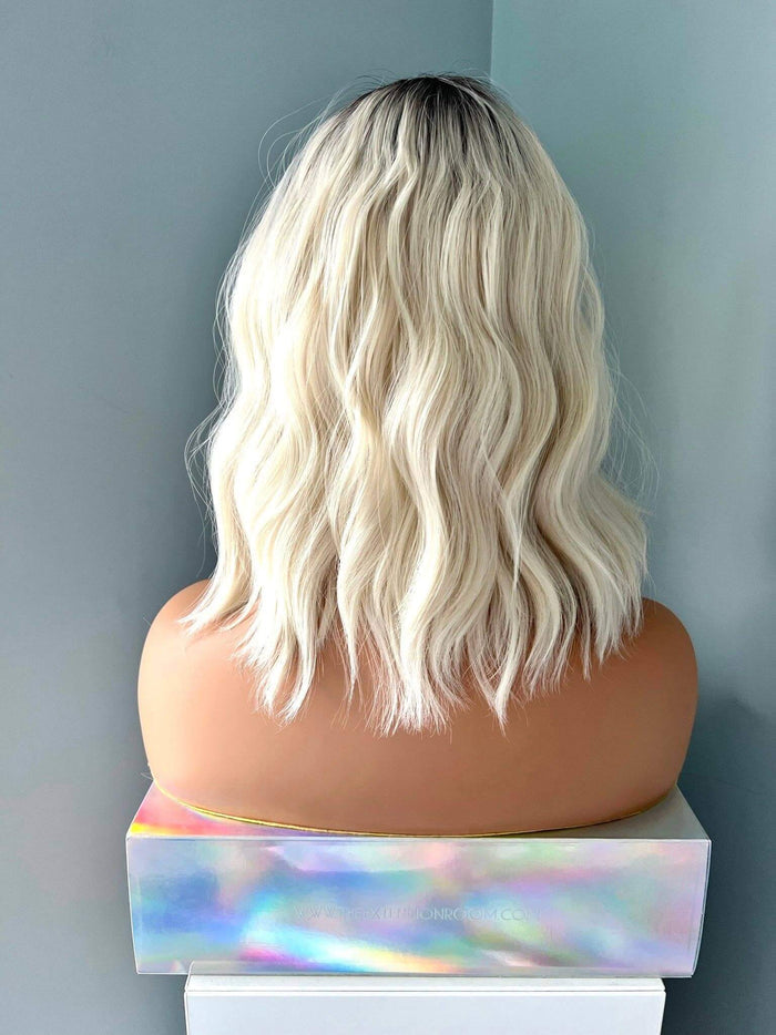Back view of a Lilah Short White Blonde Body Wave Wig with Bangs, showcasing soft waves and a stylish cut.