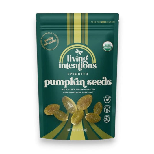 A beige and gold pouch of LIVING INTENTIONS - SALTED SPROUTED PUMPKIN SEEDS displays scattered sprouted pumpkin seeds on the front. The packaging highlights that this organic snack from LIVING INTENTIONS is made with Himalayan salt and features non-GMO, gluten-free, and USDA organic labels.