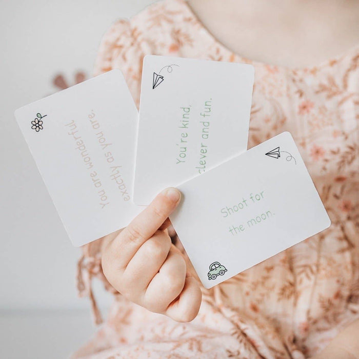 Child holding three Love Notes - Mindful and Co Kids affirmation cards promoting positivity and self-love.
