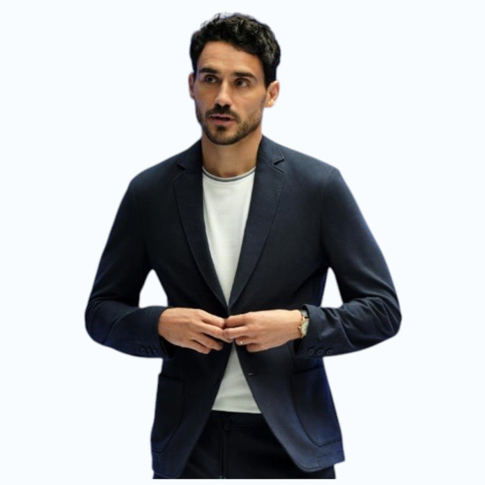 A person in a navy shirt holds open the MACK WELDON ACE BLAZER IN TRUE BLACK, revealing its comfortable, machine-washable design with an inside pocket and inner lining.