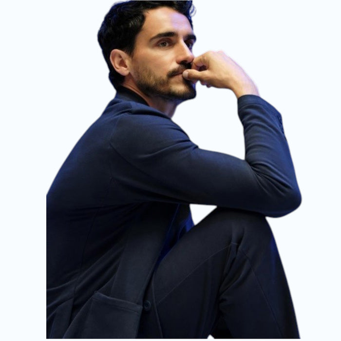 A person in a navy shirt holds open the MACK WELDON ACE BLAZER IN TRUE BLACK, revealing its comfortable, machine-washable design with an inside pocket and inner lining.
