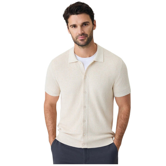 A close-up of a person wearing the MACK WELDON Tech Linen Button Up Sweater Polo in Latte Heather with dark pants, their arm relaxed by their side against a neutral background.