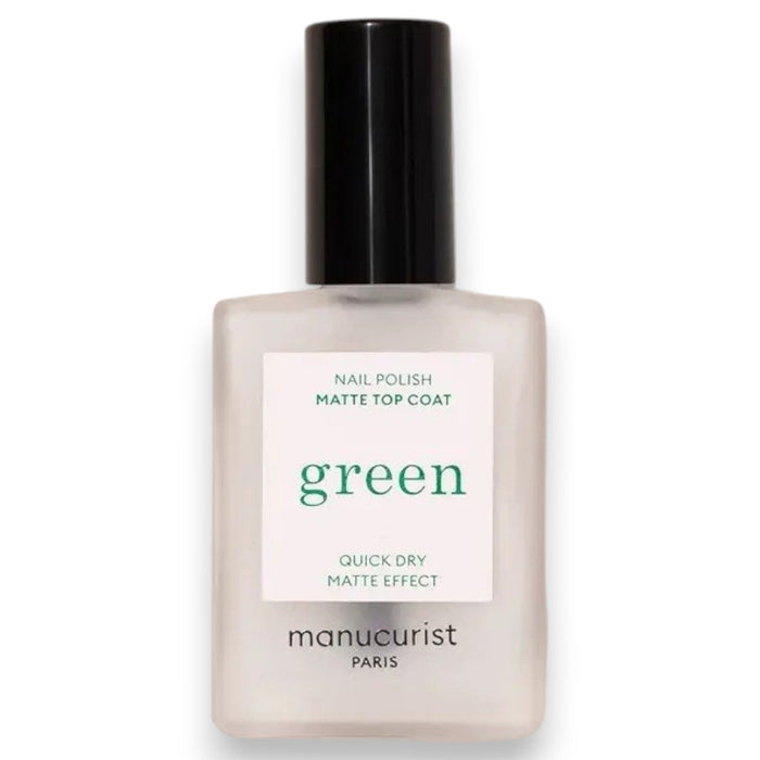 A hand with light blue painted nails holds a bottle of MANUCURIST - GREEN™ Nail Polish Matte Top Coat by MANUCURIST INC, featuring a black cap and clear plant-based formula, against a beige background.