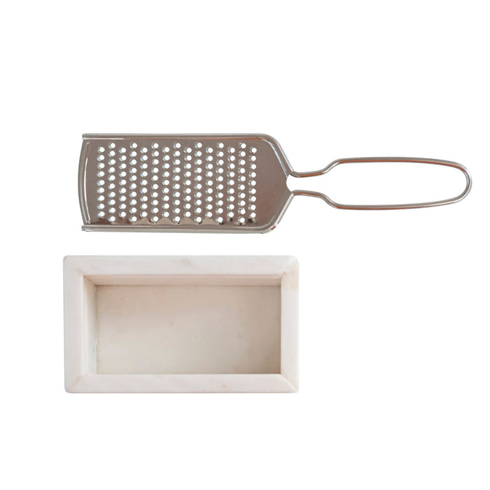 The CREATIVE COOP MARBLE AND STAINLESS STEEL GRATER, with its sleek handle and white marble rest, is shown from above, making it a stylish and modern addition to any kitchen countertop.