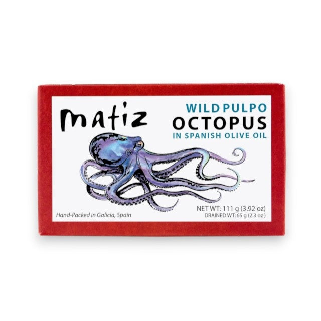 A rectangular tin can with a red border and white label. The label features an illustration of a purple octopus and text that reads "MATIZ - PULPO (OCTOPUS) IN OLIVE OIL" by MATIZ ESPANA and "Hand-Packed in Galicia, Spain." The net weight is 111g (4 oz).