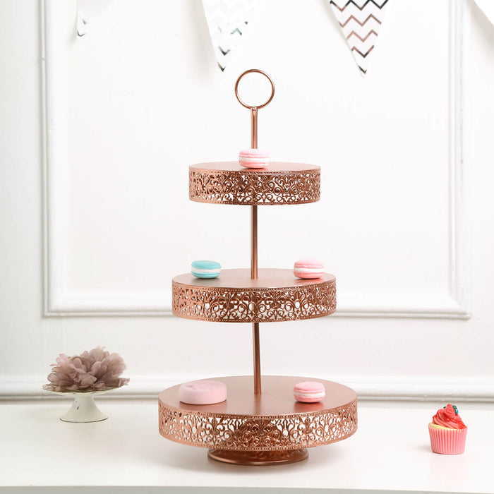 Three-tiered rose gold cake stand with decorative cutouts and colorful macarons.