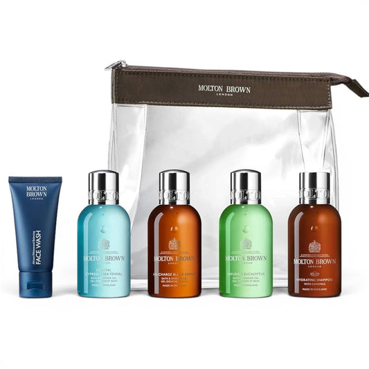 The MOLTON BROWN Refreshed Adventurer Body & Hair Carry-On Bag includes a clear bag with brown zipper, four color-labeled travel-size bath and shower gels, and a blue face wash tube on the left—a stylish set for travel from MOLTON BROWN.