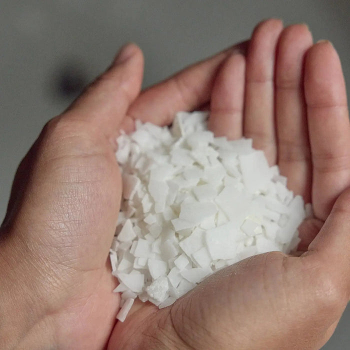 A white packet labeled “MOTHER MOTHER - MAGNESIUM BATH SOAK 3OZ” from the brand MOTHER MOTHER stands upright on a light surface, with a small pile of pure white magnesium chloride flakes—sourced from Zechstein magnesium—in front of it. The minimalist packaging features green text and simple design, making it perfect for a restorative bath experience.