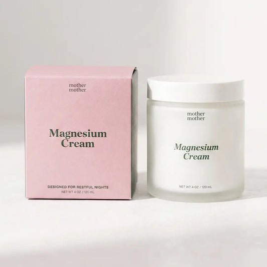 A pink box and a glass jar, both labeled “MOTHER MOTHER - MAGNESIUM CREAM” from the brand MOTHER MOTHER, are arranged side by side on a light surface. The box emphasizes its relaxation support for restful nights, while the unscented magnesium cream in the jar comes with a clean white lid.