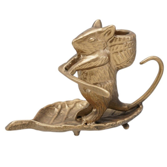 The CREATIVE COOP MOUSE ON LEAF CAST METAL TAPER HOLDER features an antique gold finish, measures 6"L x 3.25"H, and has a curled tail while sitting on a leaf-shaped base. Shown on a white background.