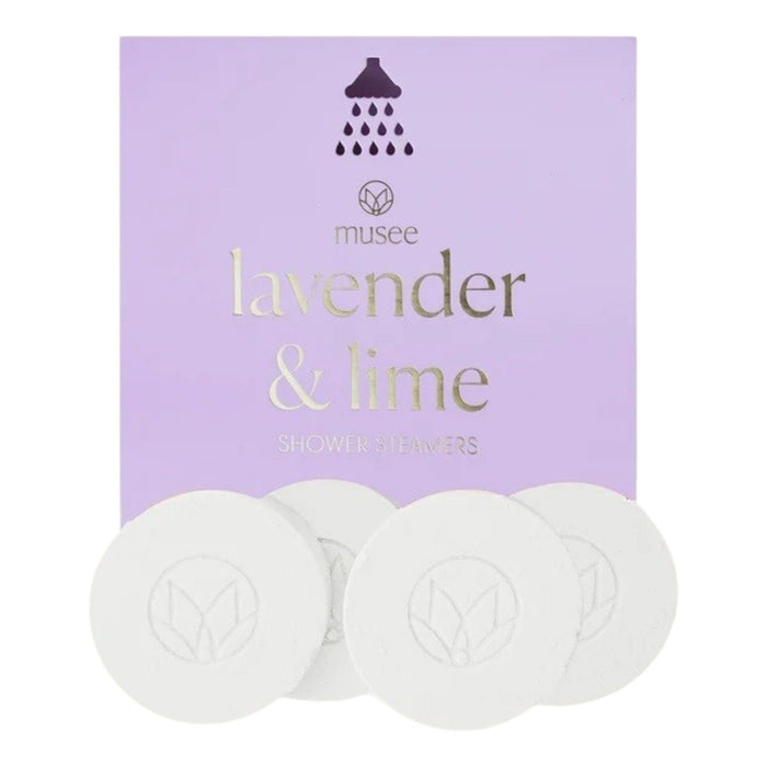 A box of MUSEE - LAVENDER & LIME SHOWER STEAMERS by MUSEE is shown with four round white steamers placed in front. The light purple packaging features gold text and a small shower icon, making it an ideal self-care treat for enhancing any shower routine.