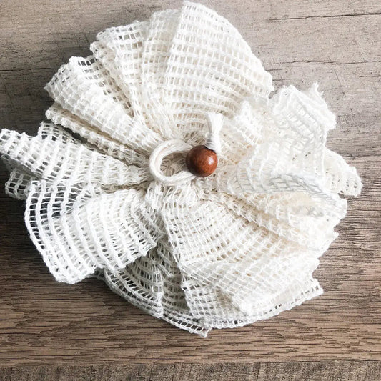White textured flower with a brown center on a wooden surface