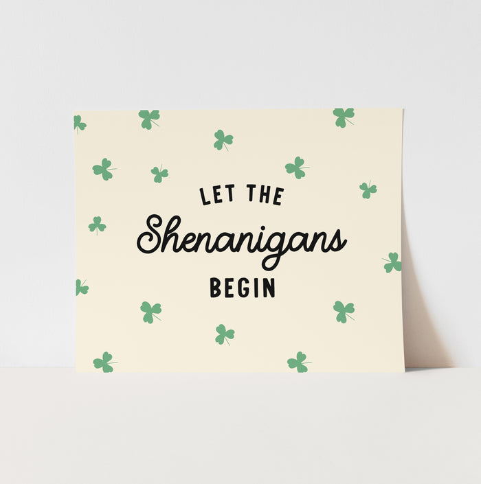 Greeting card with 'Let the Shenanigans Begin' text and shamrock pattern on a light background