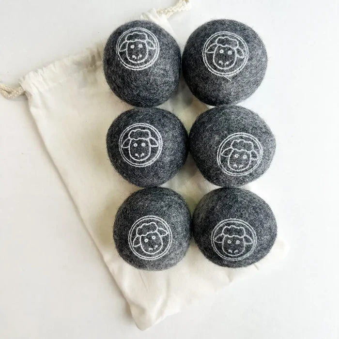 Set of six black laundry detergent pods with sheep design on a white background