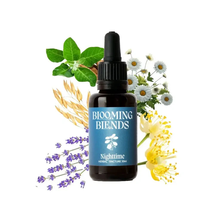 Bottle of Blooming Blends Nighttime Herbal Tincture surrounded by flowers and leaves on a white background
