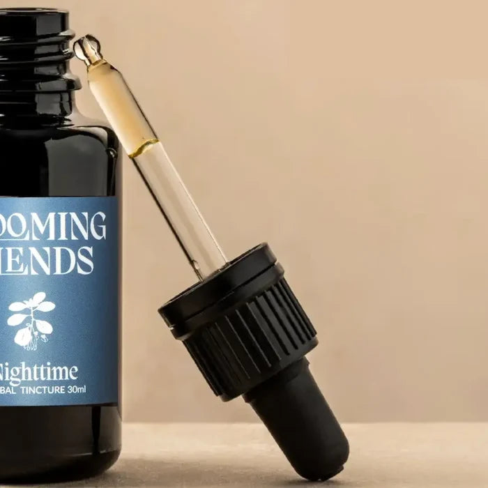 Bottle of 'Booming Tendens' tincture with dropper on a beige background