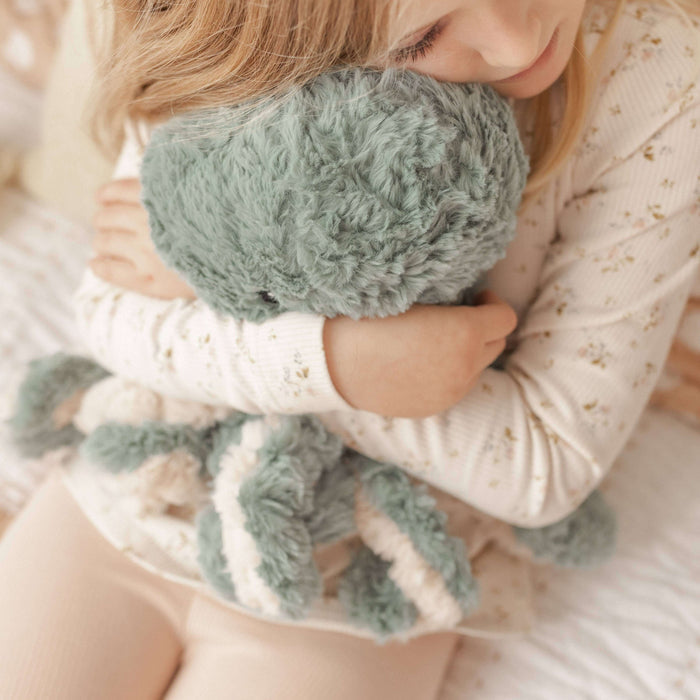 Person holding a green knitted Weighted Teddy with a soft background