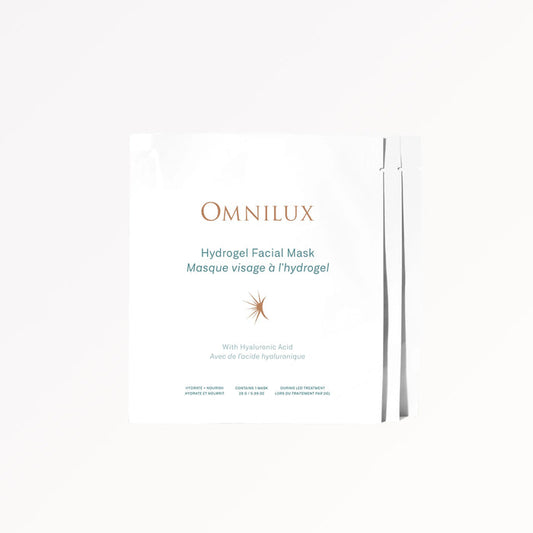 A woman removes an OMNILUX - HYDROGEL FACIAL MASK infused with Hyaluronic Acid from her face. Text above reads, “Includes 3 Hydrogel Facial Masks by OMNILUX.”.