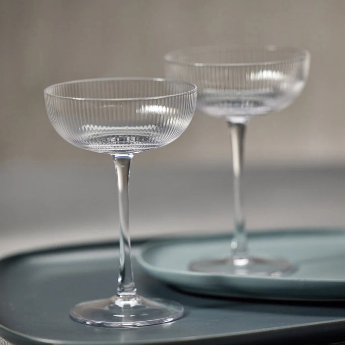 The ZODAX OPTIC DESIGN MARTINI GLASS, with its wide, shallow bowl and slender stem, stands upright against a white background—ideal for modern bars or as an elegant martini glass alternative.