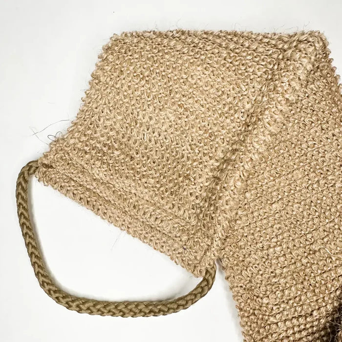 Beige woven bag with a handle on a white background
