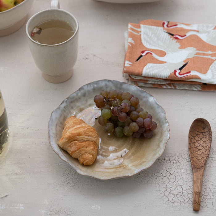 Two views of the CREATIVE COOP ORGANIC-SHAPED STONEWARE PLATE WITH REACTIVE GLAZE: one from above and one from the side, showcasing its scalloped edge and textured surface—a refined artisanal dinnerware piece.