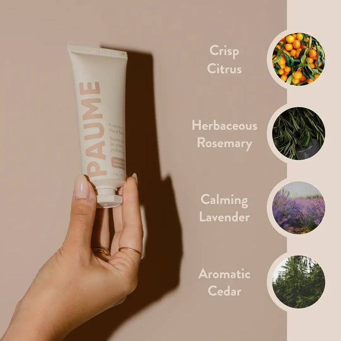 The PAUME - PROBIOTIC HAND BALM 2OZ stands upright with a beige cap on a matching background, featuring minimalist packaging with "PAUME" vertically and enriched with natural probiotics for anti-aging care.