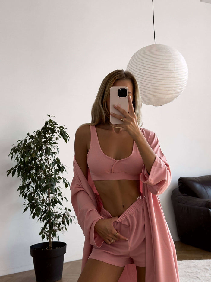 PEACE 3 Piece lounge suit - Pink worn by a model in a bright, minimalist room with plants.