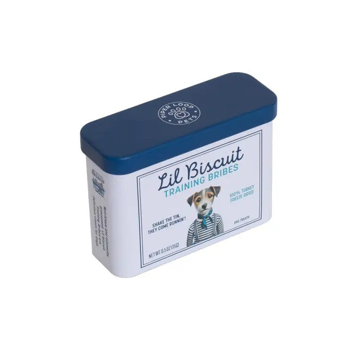 A rectangular tin with a blue lid labeled “PIPER LOOP PETS - LIL BISCUIT TRAINING BRIBES, FREEZE-DRIED TURKEY” features a puppy photo and contains 100% turkey, protein-rich treats for training and emergency recall.