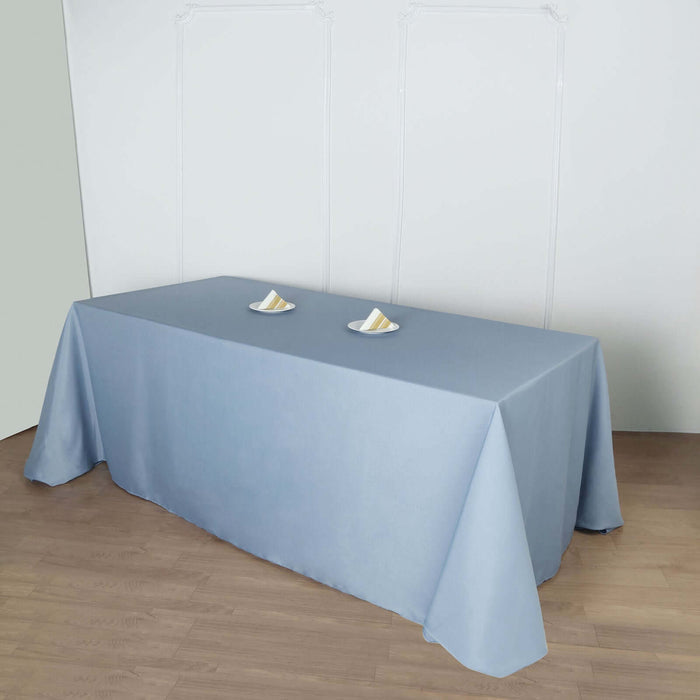 Blue tablecloth draped over a table with two plates on top.