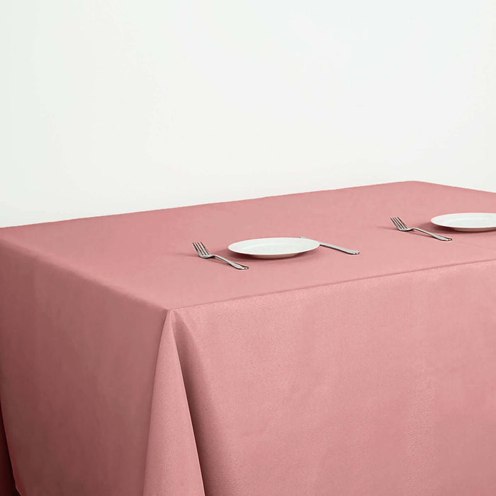 Pink tablecloth with white plates and forks set for dining