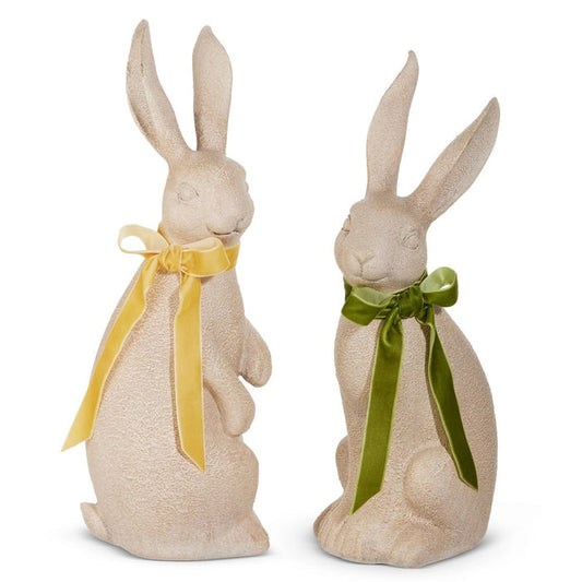 The RAZ IMPORTS RABBIT WITH BOW features two upright, concrete-look rabbit figurines with textured surfaces and yellow or green bows—charming rustic décor accents for any space.