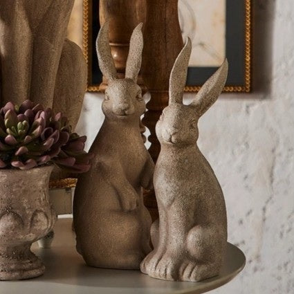 The RAZ IMPORTS RABBIT WITH BOW features two upright, concrete-look rabbit figurines with textured surfaces and yellow or green bows—charming rustic décor accents for any space.