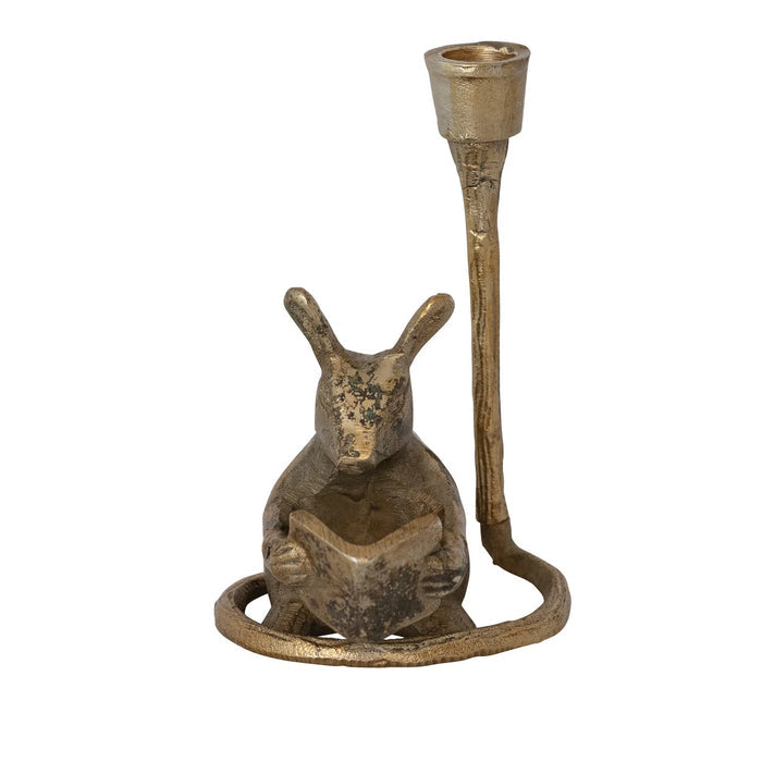 The READING MOUSE CAST ALUMINUM TAPER HOLDER by CREATIVE COOP features a charming mouse reading upright in an antique gold finish, with a candle holder above its head—a playful accent for your space.