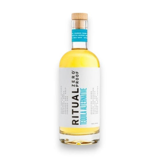 A bottle of RITUAL ZERO PROOF - TEQUILA ALTERNATIVE by RITUAL ZERO PROOF, a non-alcoholic tequila with a white label, blue accents, and a wooden cap, standing upright on a white background.