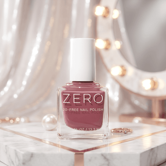 Nail polish bottle labeled 'ZERO' on a marble surface with decorative lights in the background