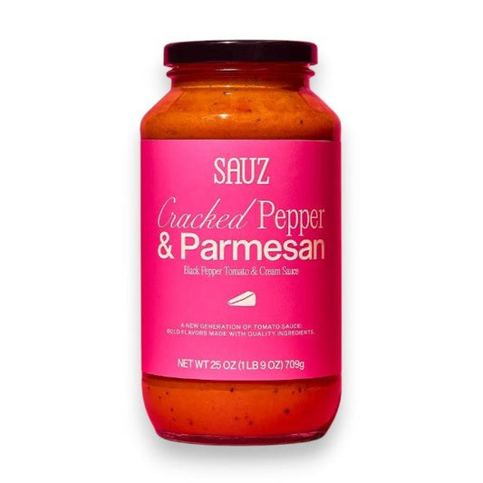 A jar of SAUZ - CRACKED PEPPER & PARMESAN sauce from SAUZ, made with California grown tomatoes and displayed in a jar featuring a bright pink label on a white background.