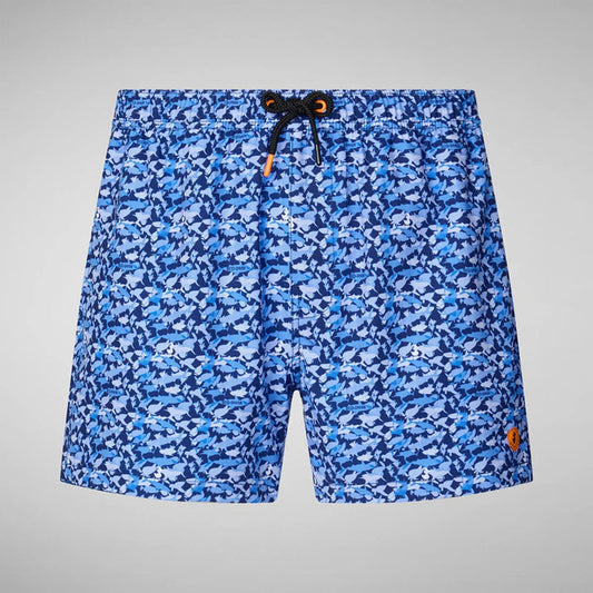 SAVE THE DUCK - ADEMIR SWIM TRUNKS IN BLUE SHARK: Quick-dry recycled polyester men's swim trunks featuring a blue and navy shark print, drawstring waistband, orange logo patch on the lower left leg, and plain light gray background.