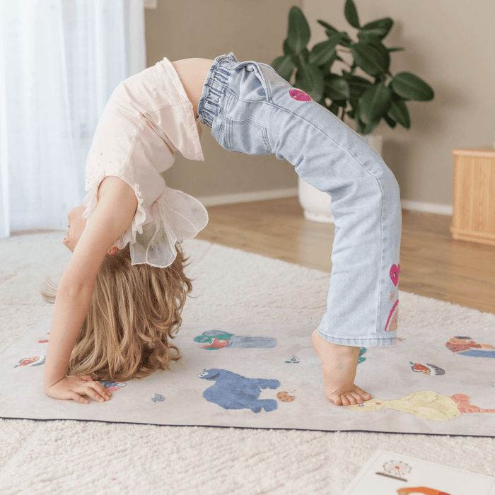 Child practicing yoga on a colorful Sesame Street Print Kids Yoga Mat, showcasing fun characters.