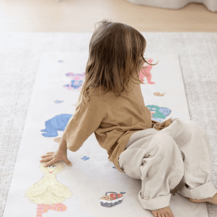 Child practicing yoga on Sesame Street Print Kids Yoga Mat featuring beloved characters in playful poses.