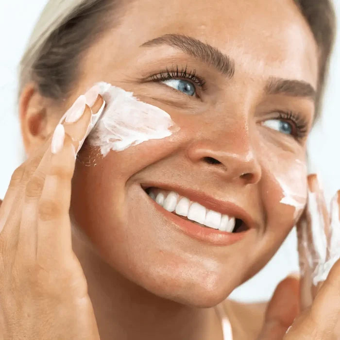 Woman applying cream to her face with a blurred background
