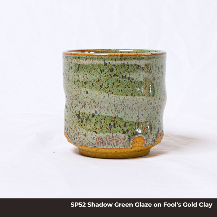 Cup in SP52 Shadow Green glaze on Fool's Gold clay, speckled sage green with an unglazed golden foot